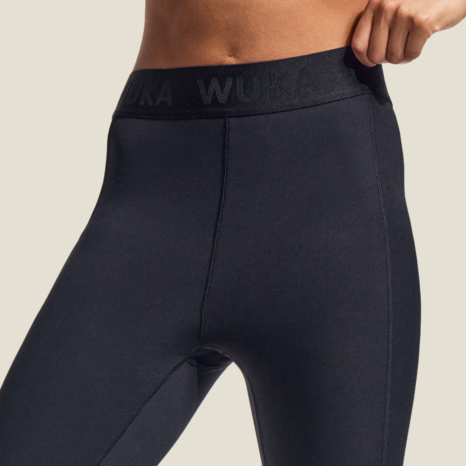 Close-up of WUKA branded waistband and soft performance fabric of medium flow period leggings for athletic support.