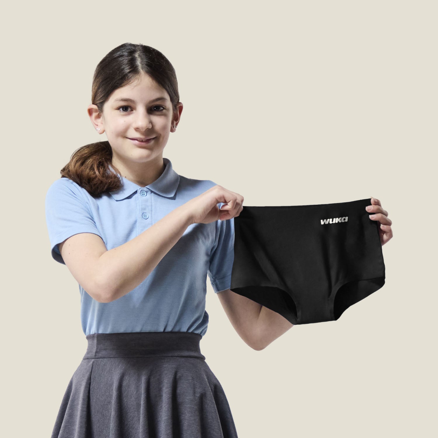 Teen demonstrating the stretchability of WUKA Stretch™ Boxer, designed to adapt up to 3 sizes for growing teens.