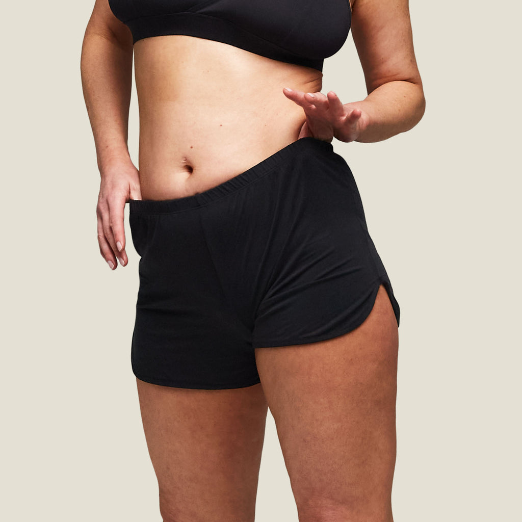 Close-up front view of WUKA Pyjama Jersey Shorts in black, featuring soft, breathable fabric and curved side slits for enhanced comfort and airflow.