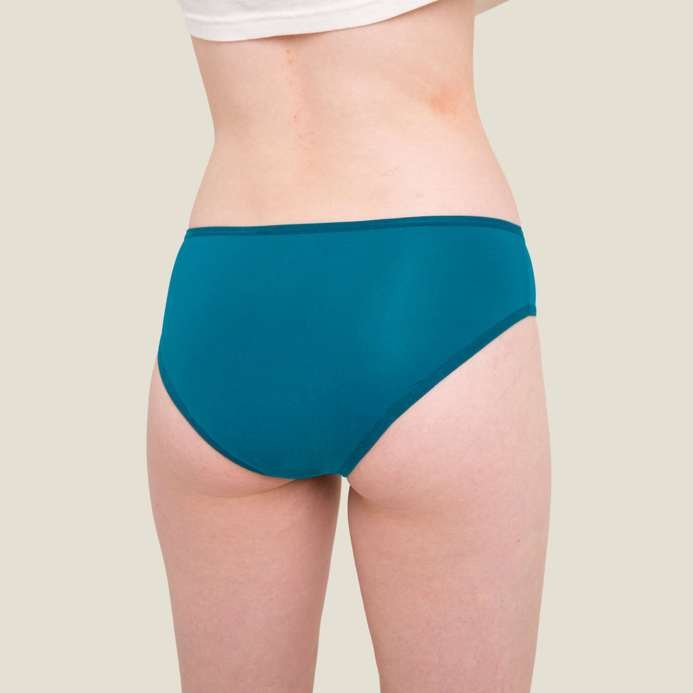 Back view of WUKA Teen Swim Bikini Brief in blue for light period flow, highlighting secure coverage and sleek swimwear fit.