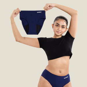 Teen model holding a pair of WUKA navy seamless period pants, showcasing size flexibility and sustainable design for young menstruators.
